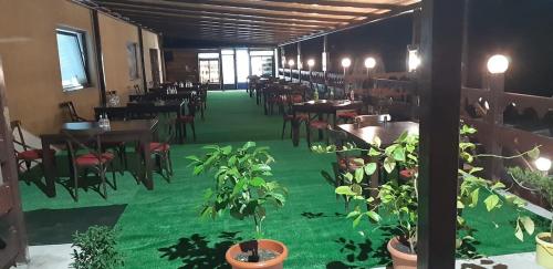a dining room with tables and chairs and green carpet at La Neamțu in Văliug