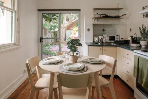 a kitchen with a table and chairs with a table and a window at Chic 2BR Terrace w City and Harbour Bridge Views in Sydney