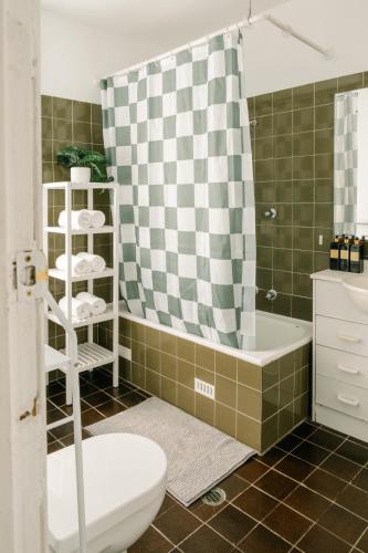 a bathroom with a toilet and a shower curtain at Chic 2BR Terrace w City and Harbour Bridge Views in Sydney
