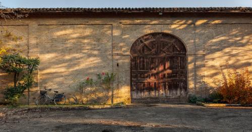 an old building with a large door and a bike at Villa D&D in Parma