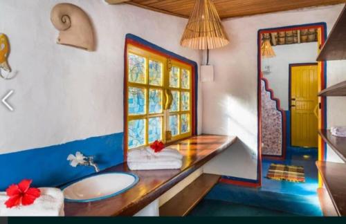 um banheiro com pia e janela em Casa Mar em Porto Seguro