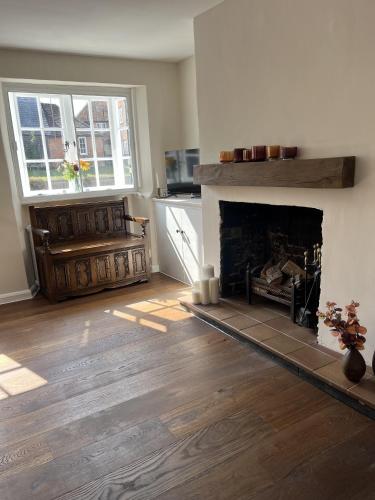 a living room with a fireplace and two windows at The Old Forge in Wendover