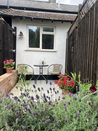 a patio with a table and chairs and flowers at The Old Forge in Wendover