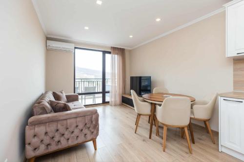 ein Wohnzimmer mit Tisch und Couch in der Unterkunft Апарт комплекс Амфора Палас in Goldstrand