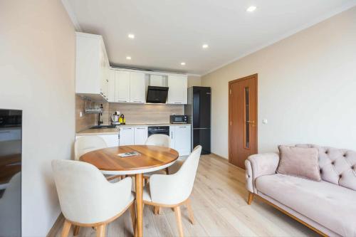 ein Wohnzimmer mit Tisch und Stühlen und einer Couch in der Unterkunft Апарт комплекс Амфора Палас in Goldstrand