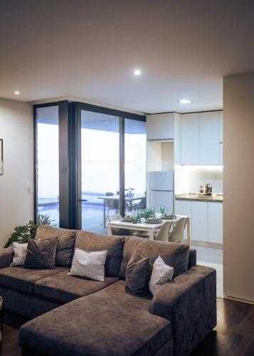 a living room with a couch and a kitchen at Portugal Alma - Oporto Guesthouse - Private Heated Pool in Ermesinde