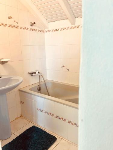 a bathroom with a tub and a sink at Ti Swell Caribbean House in Port-Louis