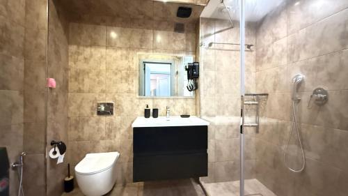 een badkamer met wastafel, douche en toilet bij Sea view luxury in Baku