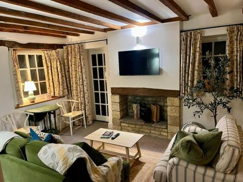 ein Wohnzimmer mit Couch und Kamin in der Unterkunft The Carriage House in Blockley