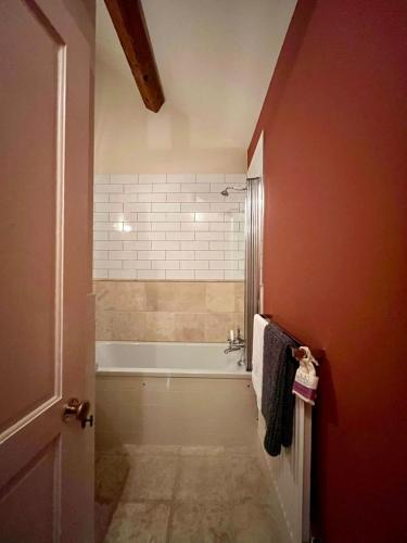 a bathroom with a bath tub and a shower at The Carriage House in Blockley