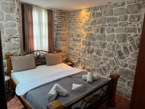 un lit dans une chambre avec un mur en pierre dans l'établissement Last Summer hotel Kotor, à Kotor