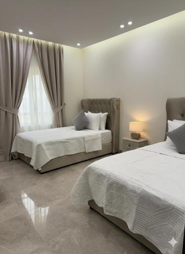 a bedroom with two beds and a window at AL Rayan Luxury Apartments in Jeddah