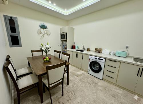 a kitchen with a table and chairs and a washing machine at 3BR 5Bed luxury apartment in Jeddah