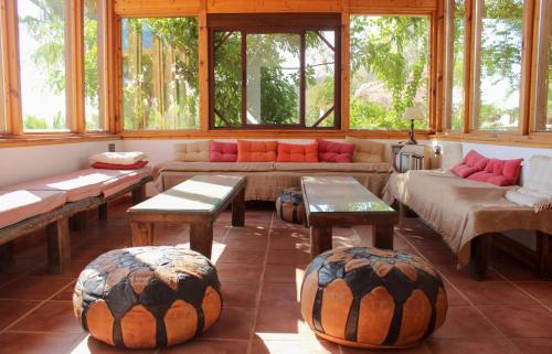a living room with couches and tables and windows at Parcela autocaravana o tienda propia - Wellnesscamp Oasis Al Hamam in Lucainena de las Torres
