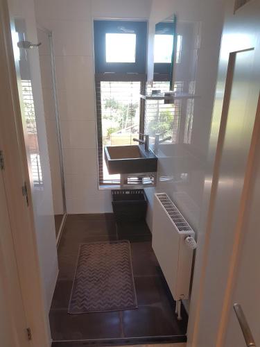 a small bathroom with a sink and a window at Casa Mirador Sleep Inn in Almere