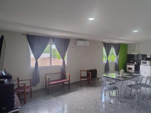 a living room with a table and chairs and a kitchen at Apart Cuyo in San Rafael