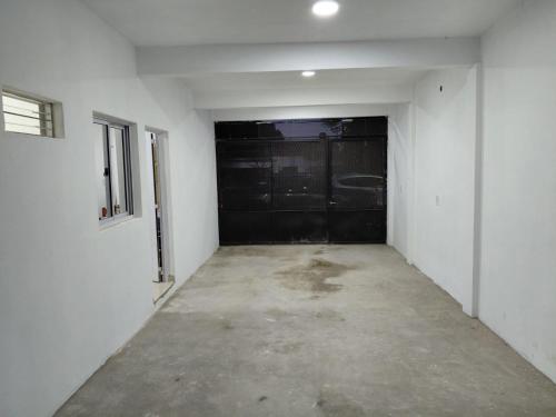 an empty garage with a black garage door at Alojamiento Marcenal in Empedrado