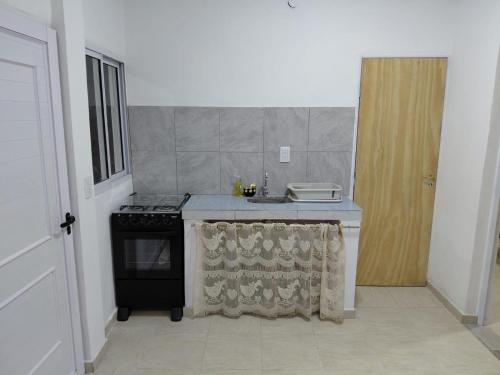 a kitchen with a stove and a sink at Alojamiento Marcenal in Empedrado