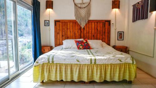 a bedroom with a bed and a large window at Casa Río Cuale and River Retreat in Puerto Vallarta