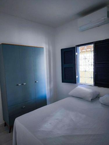 ein Schlafzimmer mit einem weißen Bett und einem blauen Schrank in der Unterkunft Casa Mahalo - no centro de Cumbuco in Caucaia
