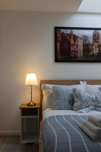 a bedroom with a bed with a lamp and a picture on the wall at Oxford Modern Living - Free Parking in Oxford
