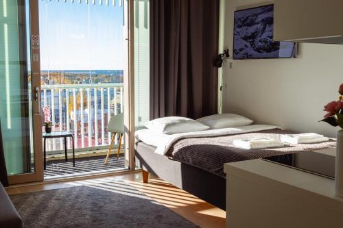 a bedroom with a bed and a balcony with a view at Penthouse in the Oulu center in Oulu
