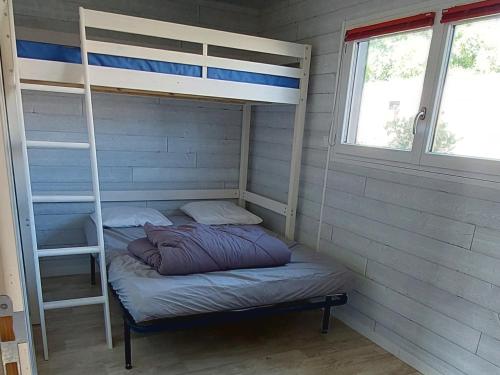 a room with two bunk beds and a ladder at chalet de 1 a 7 personnes in Hermanville-sur-Mer