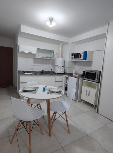 a small kitchen with a table and chairs in it at LoftPoint Rosario, Pileta, Solarium y Terraza con vista al Río in Rosario