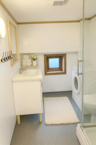 a bathroom with a sink and a washing machine at Sentralt og elegant opphold nær alt in Lillehammer