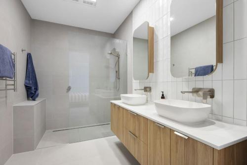 un baño con dos lavabos y una ducha en Peninsula Sea Breeze, en Safety Beach