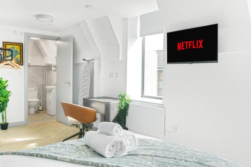 a bedroom with a bed and a tv on a wall at The City Pad in Nottingham