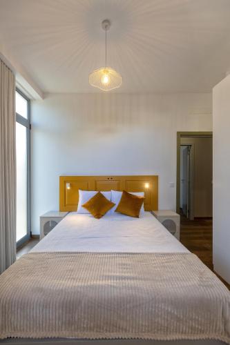 a bedroom with a large white bed with yellow pillows at THE SPOT- holiday concept in Santa Cruz
