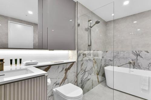 悉尼Stunning Wyndel Macquarie Apartment的带淋浴、马桶和水槽的浴室