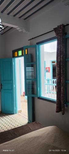 a room with a window and a bed and a door at Dar darko in Essaouira