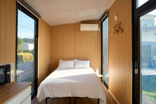 a bedroom with a bed and a large window at Kirisawabase Tiny House by Tiny Away in Nagaoka