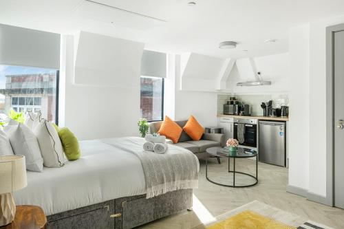 a bedroom with a large bed and a kitchen at The City Pad in Nottingham