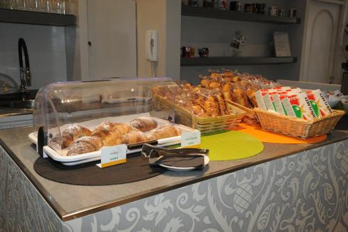 a counter with a bunch of pastries and baskets of bread at Hotel del Ponte in Cesate