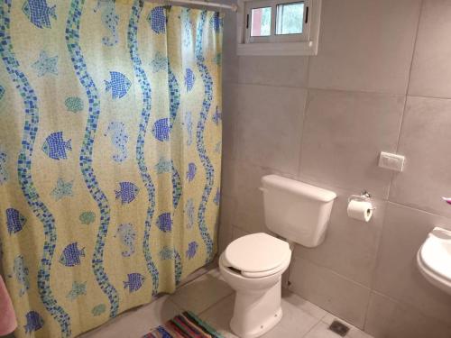 een badkamer met toilet en douchegordijn bij Playa Hostel in Santa Rosa de Calamuchita