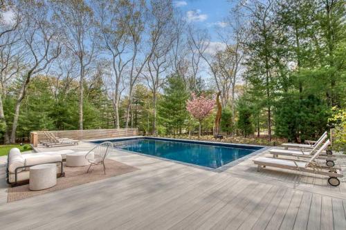 einen Pool mit Liegestühlen und ahaps in der Unterkunft Springs Cottage by Rove Travel Home with Heated Pool in Threemile Harbor