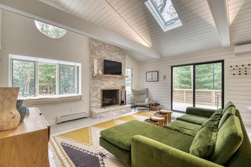 ein Wohnzimmer mit einer grünen Couch und einem Kamin in der Unterkunft Springs Cottage by Rove Travel Home with Heated Pool in Threemile Harbor