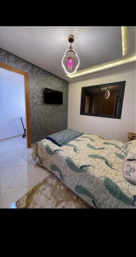 a bedroom with a bed and a chandelier at Residence Ritaj in Agadir