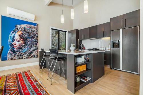 a kitchen with a kitchen island and a painting on the wall at Lake Panorama Villa in Queenstown