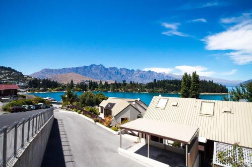 arial view of a house with a lake and mountains at The Lodges in Queenstown