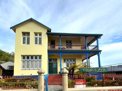 una casa amarilla y azul con una valla en Noah's Ark Flashpacker, en Greymouth