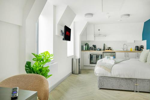 a white room with a bed and a kitchen at The City Pad in Nottingham