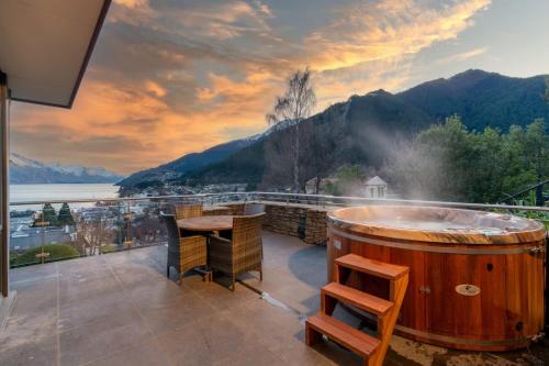 einen Whirlpool auf einem Balkon mit einem Tisch und Stühlen in der Unterkunft The Haddens in Queenstown
