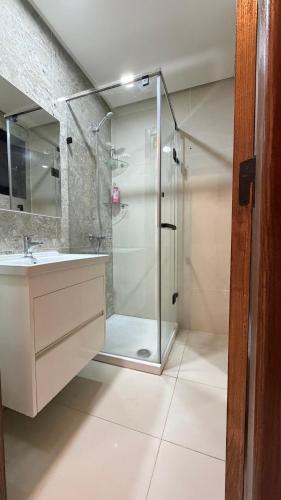 a bathroom with a glass shower and a sink at Premium Suite - Ain zaghouen - proche aeroport - linge hotel in El Aouina Station
