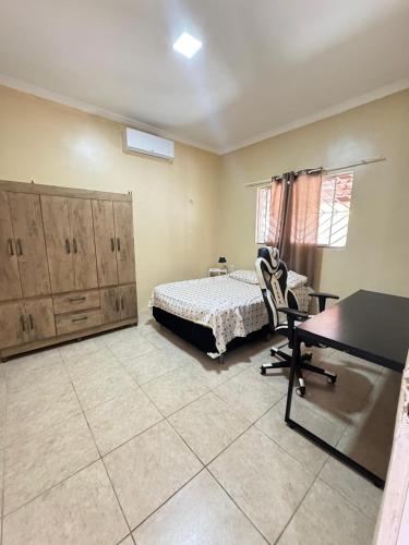 a bedroom with a bed and a desk in it at Sitio Família Freitas in Pindoretama