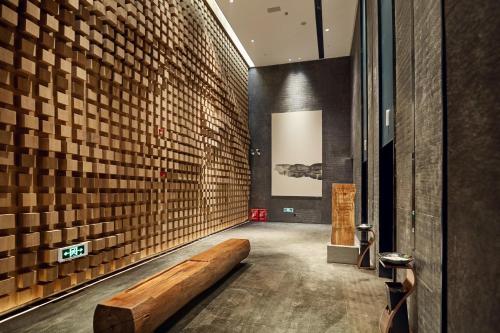 a hallway with a wooden bench in a building at 品缦芸酒店长沙高铁南站沙湾公园地铁站店 in Changsha