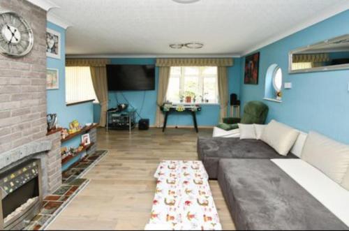 un salon avec un canapé et une cheminée dans l'établissement A lovely bungalow with 3 bedrooms and nice garden, à Boultham